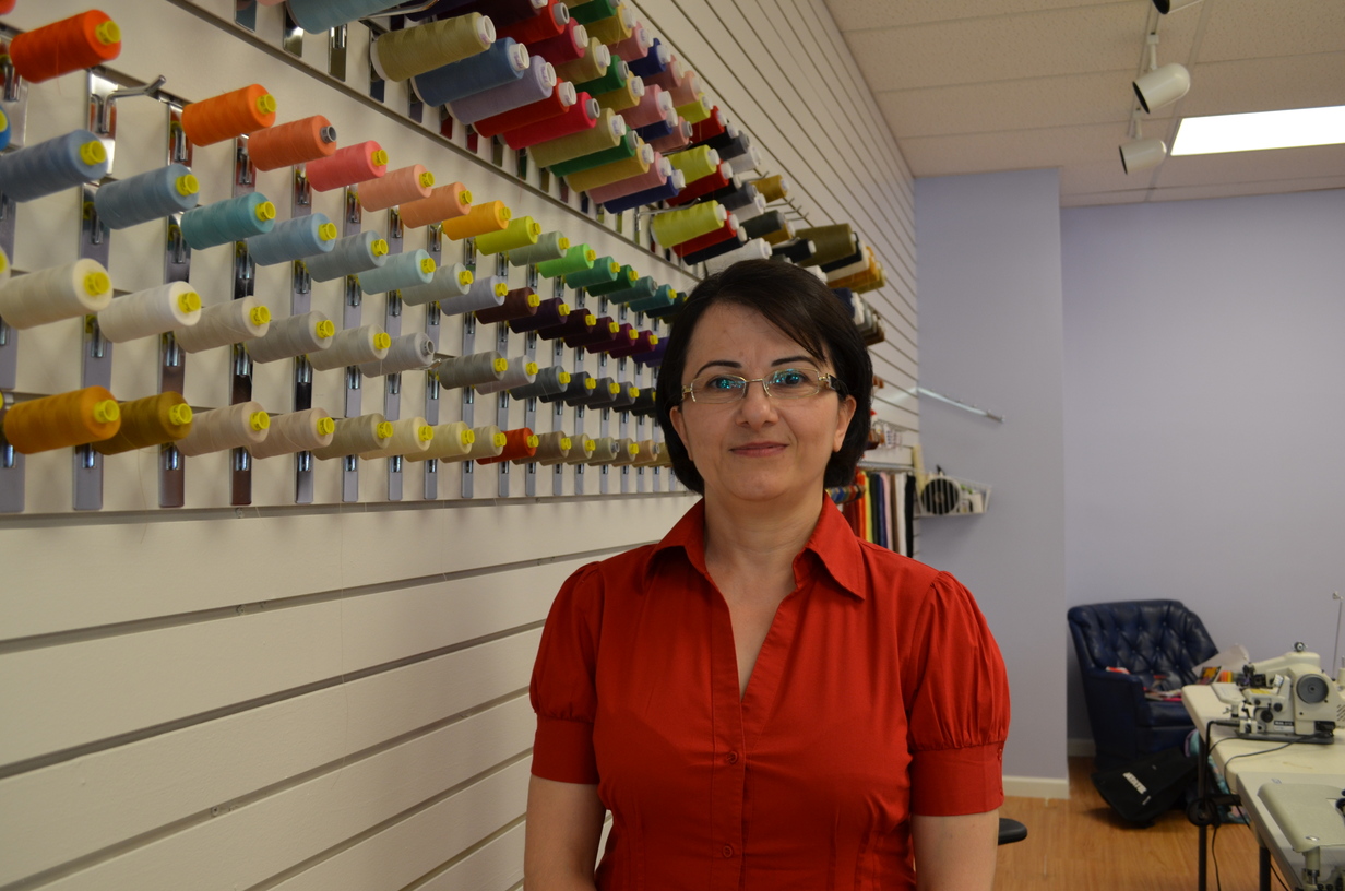 Mahnaz stands by a large collection of threads.